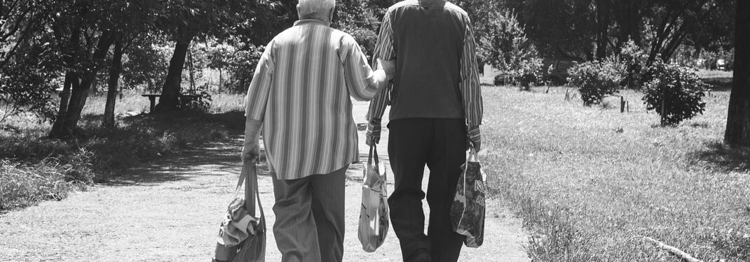 Schwarz-weiß-Bild: Ein Paar im Rentenalter geht spazieren